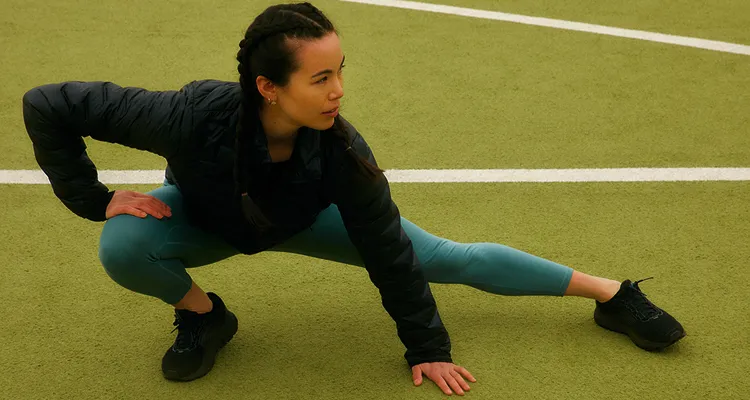 Woman stretching outdoors before exercise to improve mobility, flexibility, and support long-term health and healthy aging.