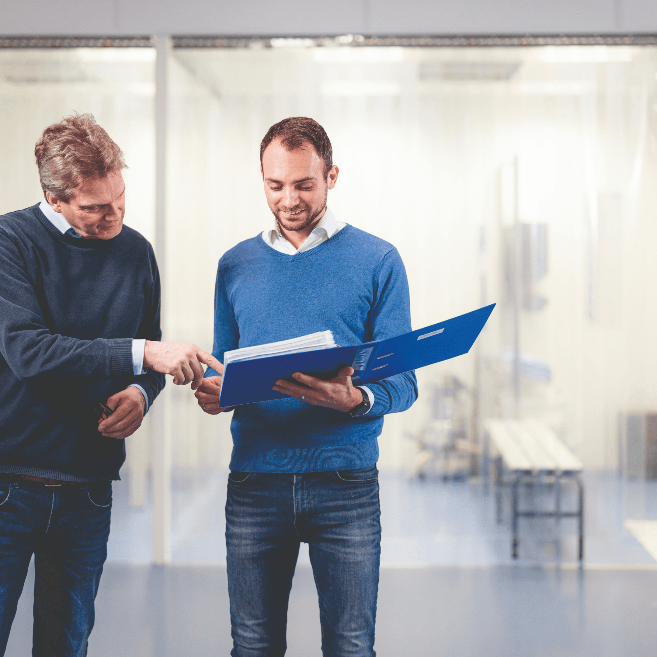 Twee mannen, één in een blauwe trui en de ander in een donkerblauwe blazer, bekijken een verbeterplan met titels en fasen, waaronder 'Machine beter afstellen' en 'Kennis medicatie vergroten'.