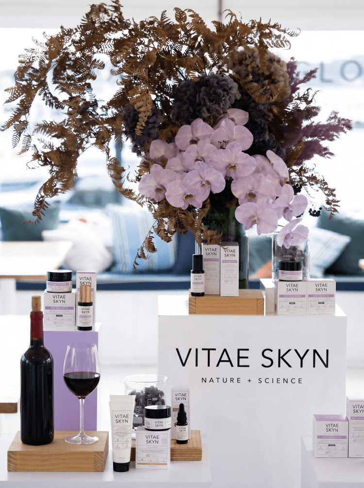 香港護膚產品推廣活動展台佈置，配以紫色蘭花花藝及紅酒裝飾，專業商務市場策劃及品牌推廣場地設計。