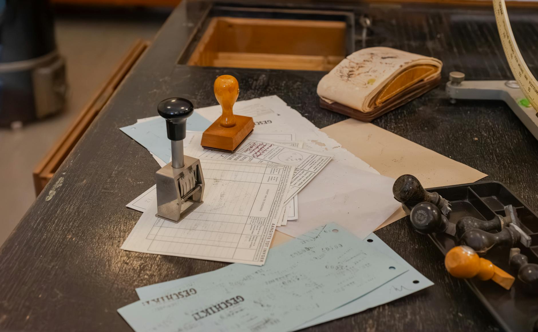 Close-up of a students hands carefully examining a vintage black and white primary source document on a wooden desk.
