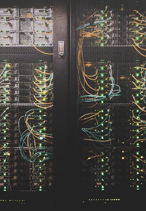 Hand holding a smartphone with a blank screen against a dark background.