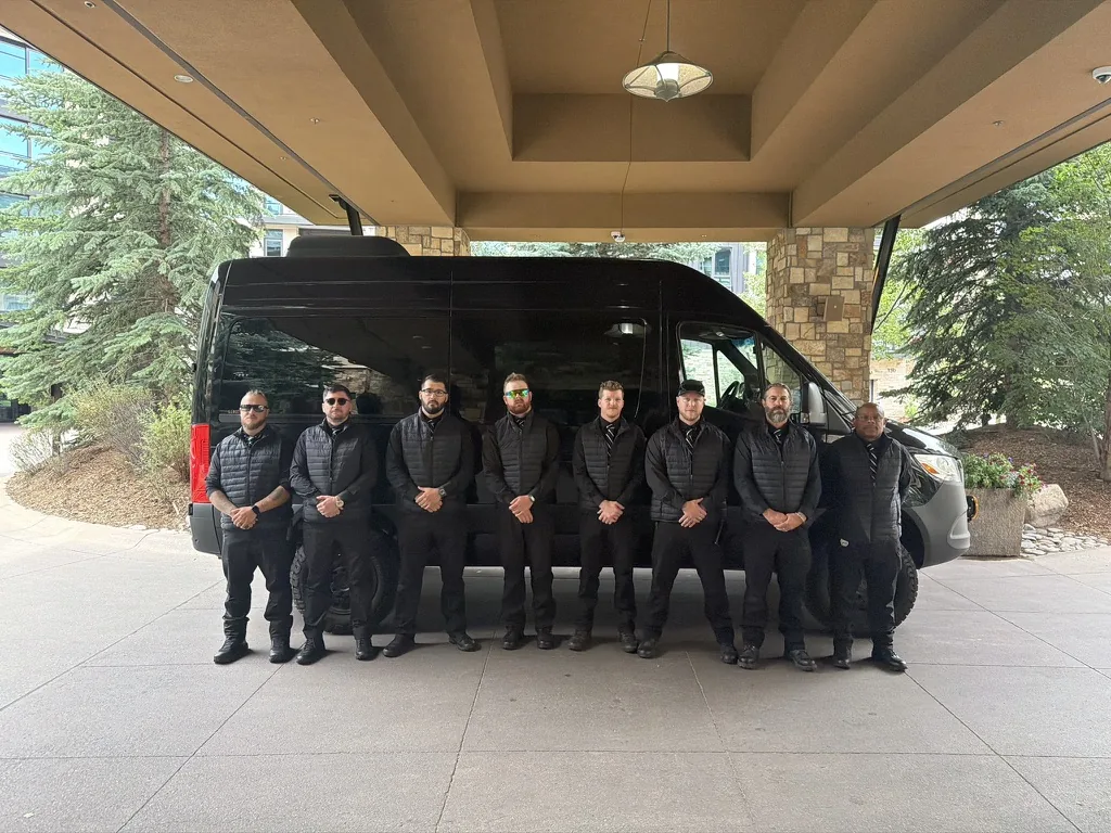 Protective team on standby under a hotel porte-cochère with a Sprinter