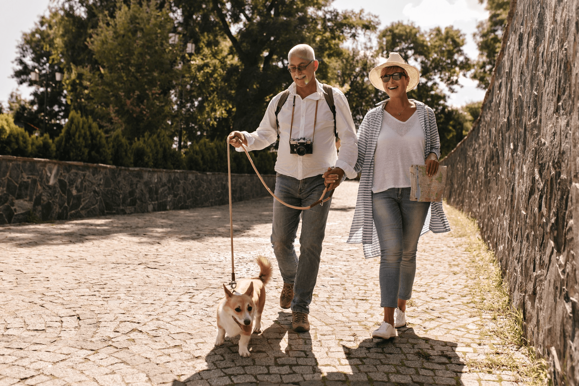 Two older adults walking a dog