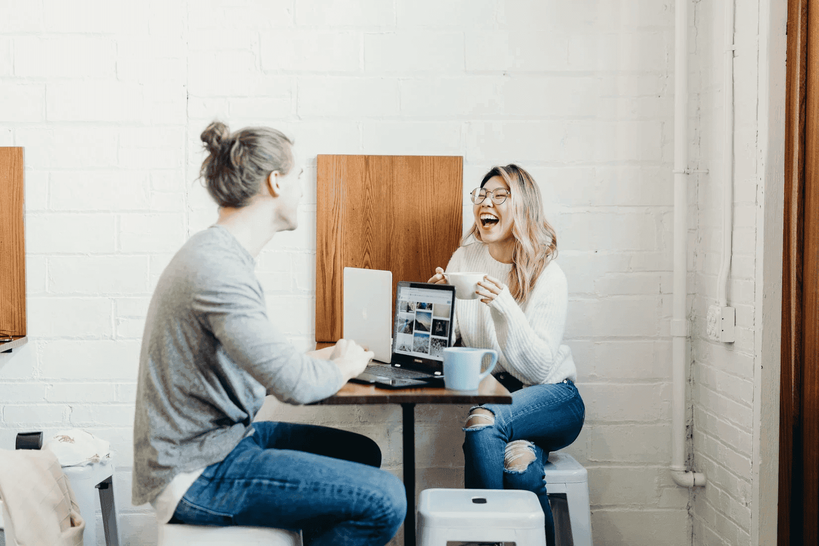 Two women working together on shared office desk for recruiters showing collaboration