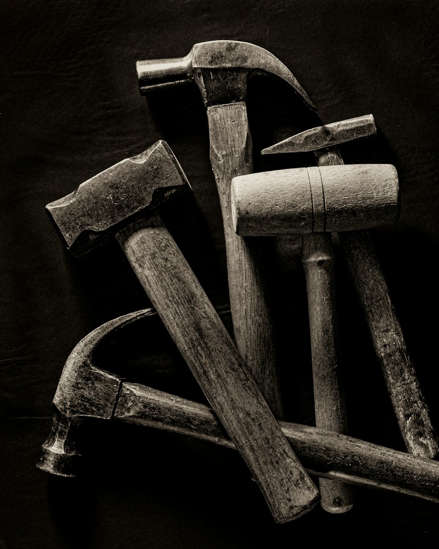 A collection of various hammers on a dark background