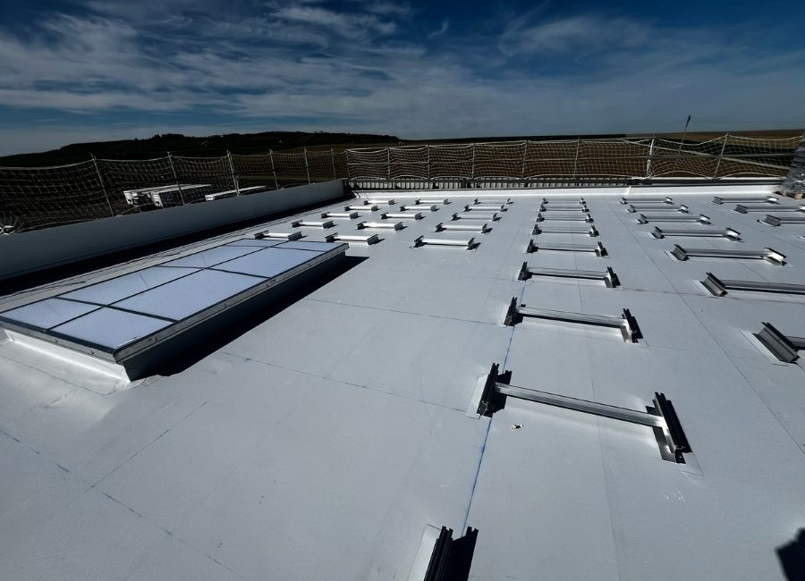 Vue aérienne d’un chantier de construction avec fondations béton et structure métallique en cours.