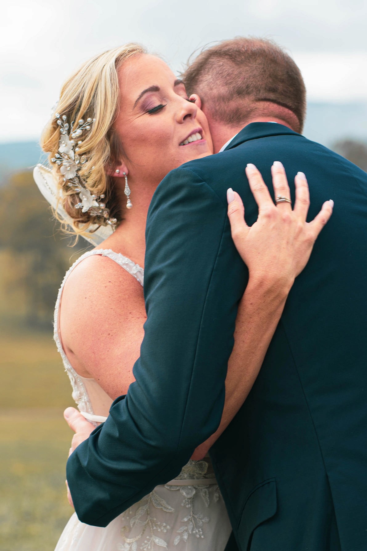 A bride and groom share a kiss surrounded by a joyful bridal party.