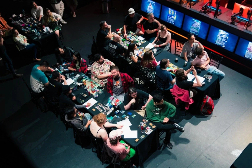 A top down view of tables with people sitting around playing tabletop games