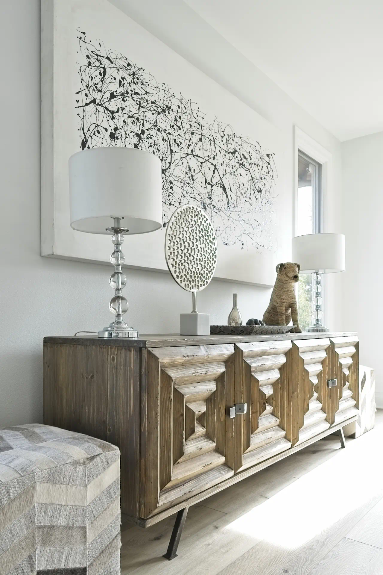 Portrait of the entertainment room console, decorated with bubble table lamps and eclectic items, showcasing the room's unique and playful character. Photo by Todd Huge.