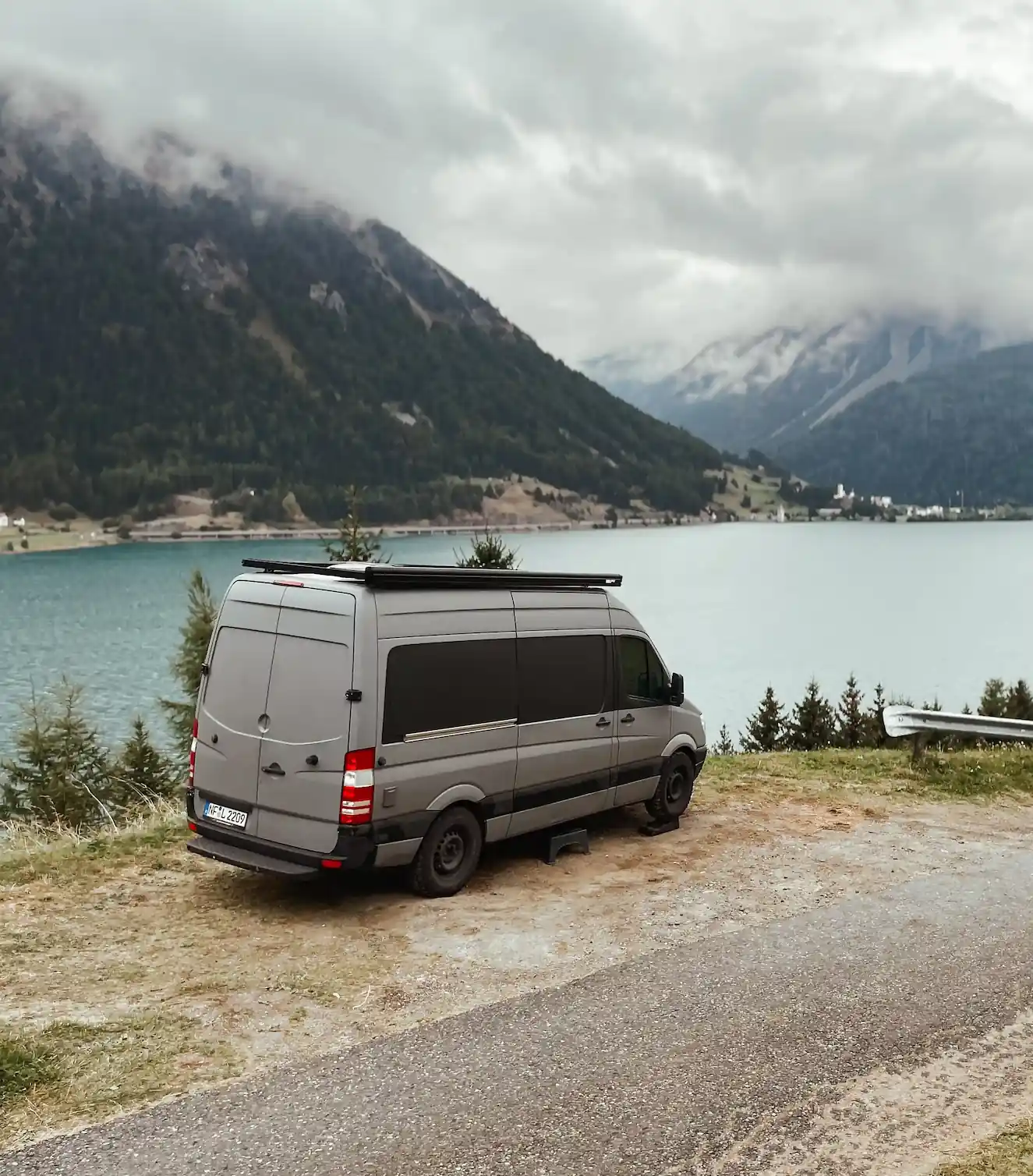 Ein Camper der vor einem see geparckt ist
