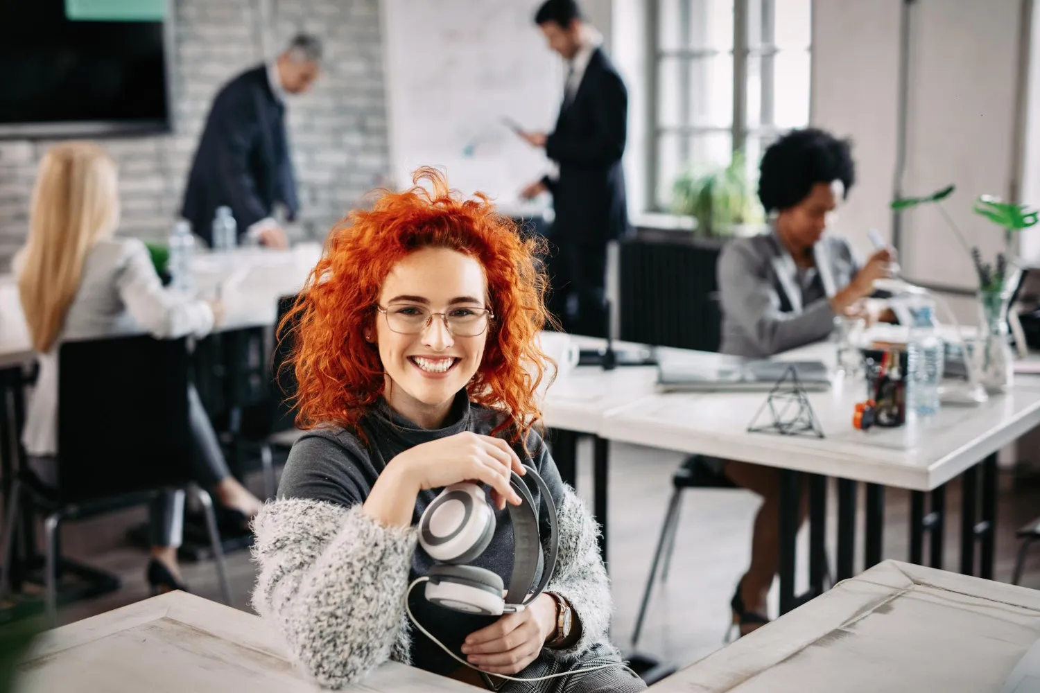 Smiling designer sitting in front of a computer in a creative agency.