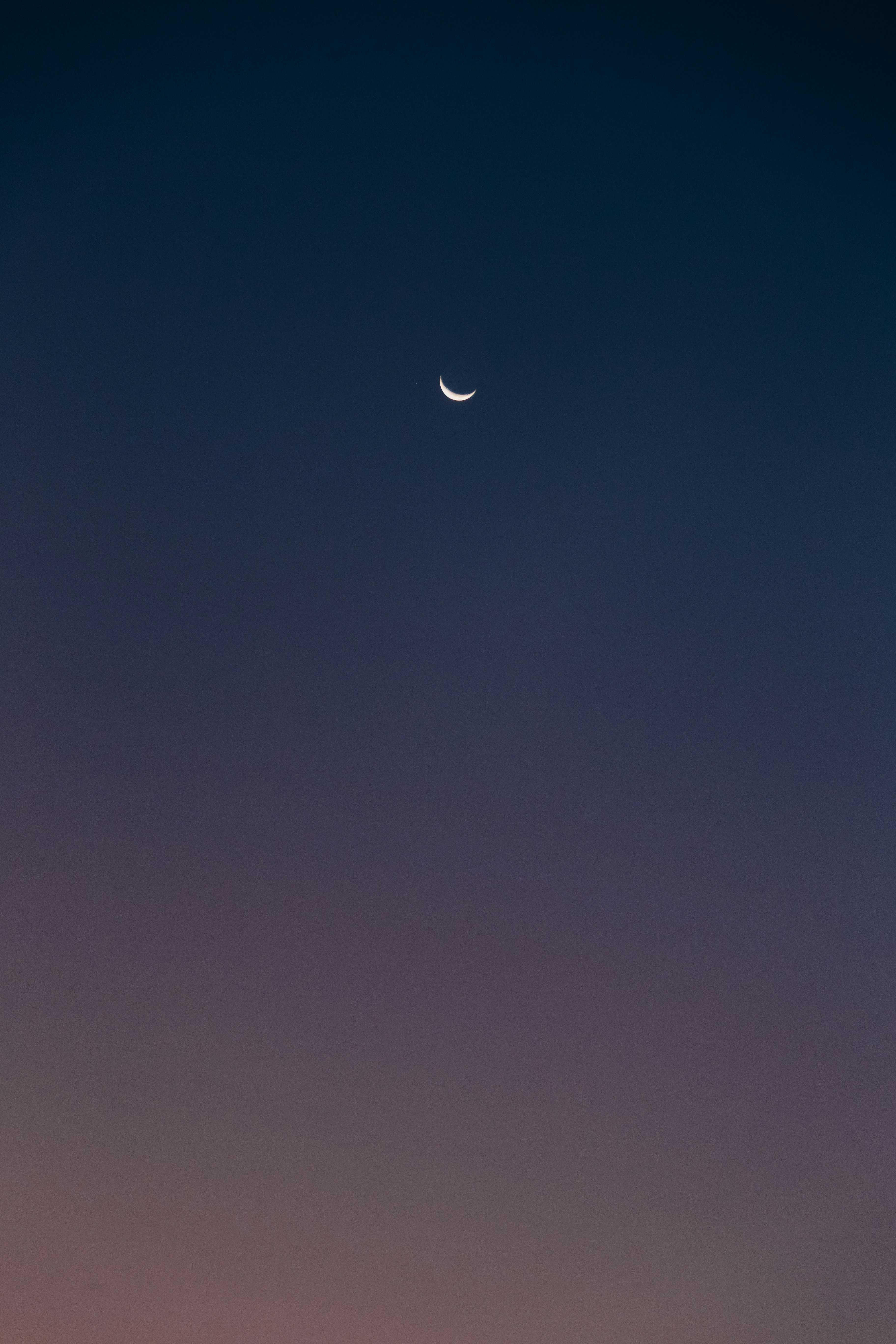 Crescent moon in a gradient twilight sky