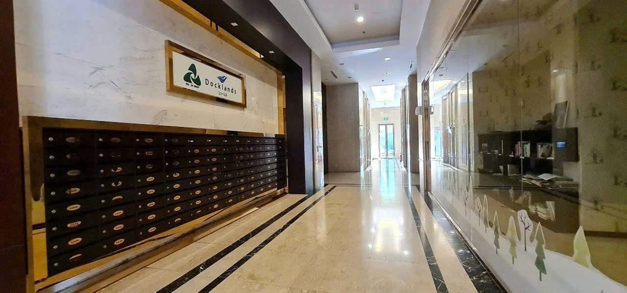 Minimalist kitchen with white island, wooden cabinets, and pendant lights.