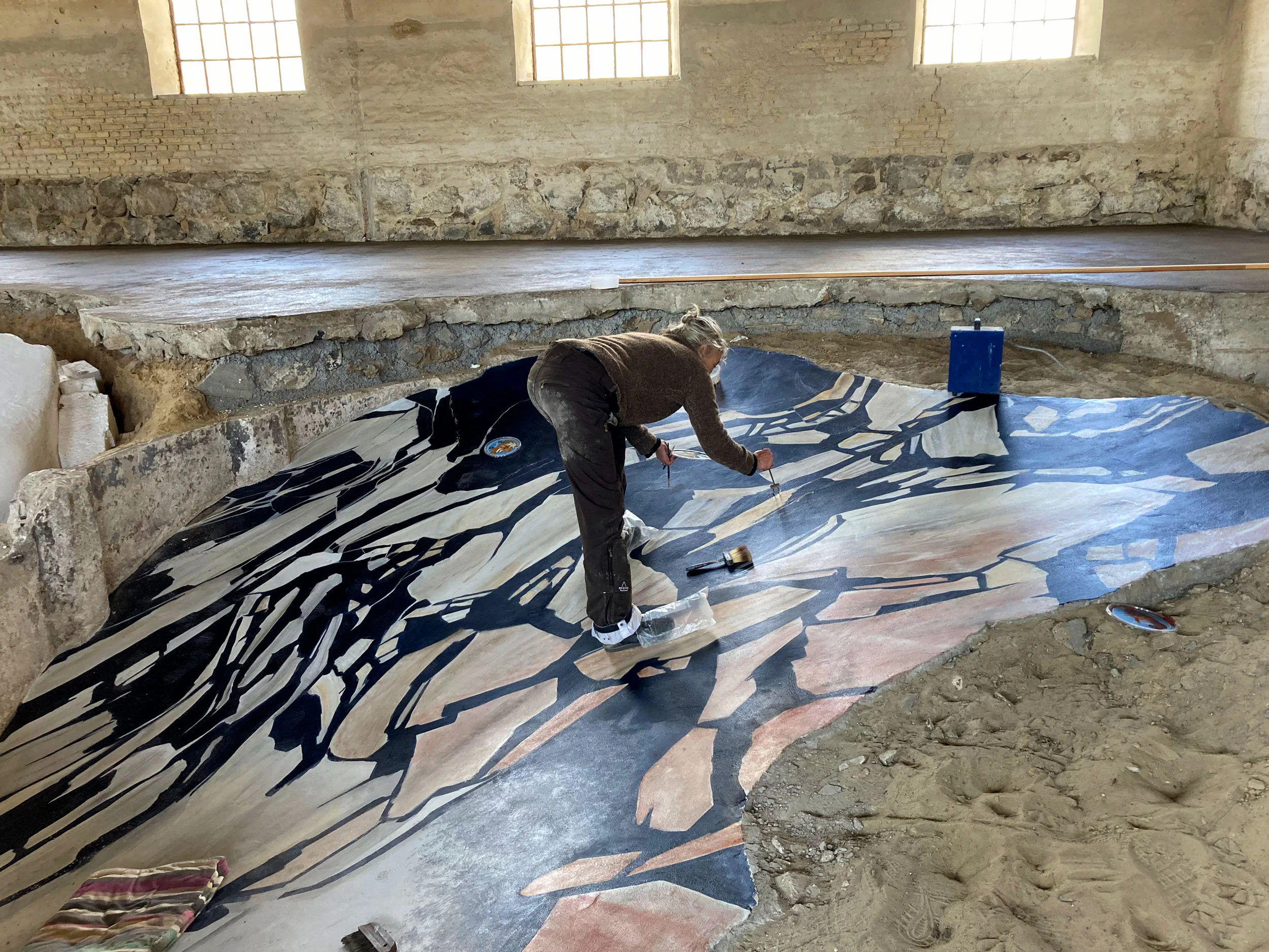 Decoration painter Susan Arnild marbling the grinded concrete floor.