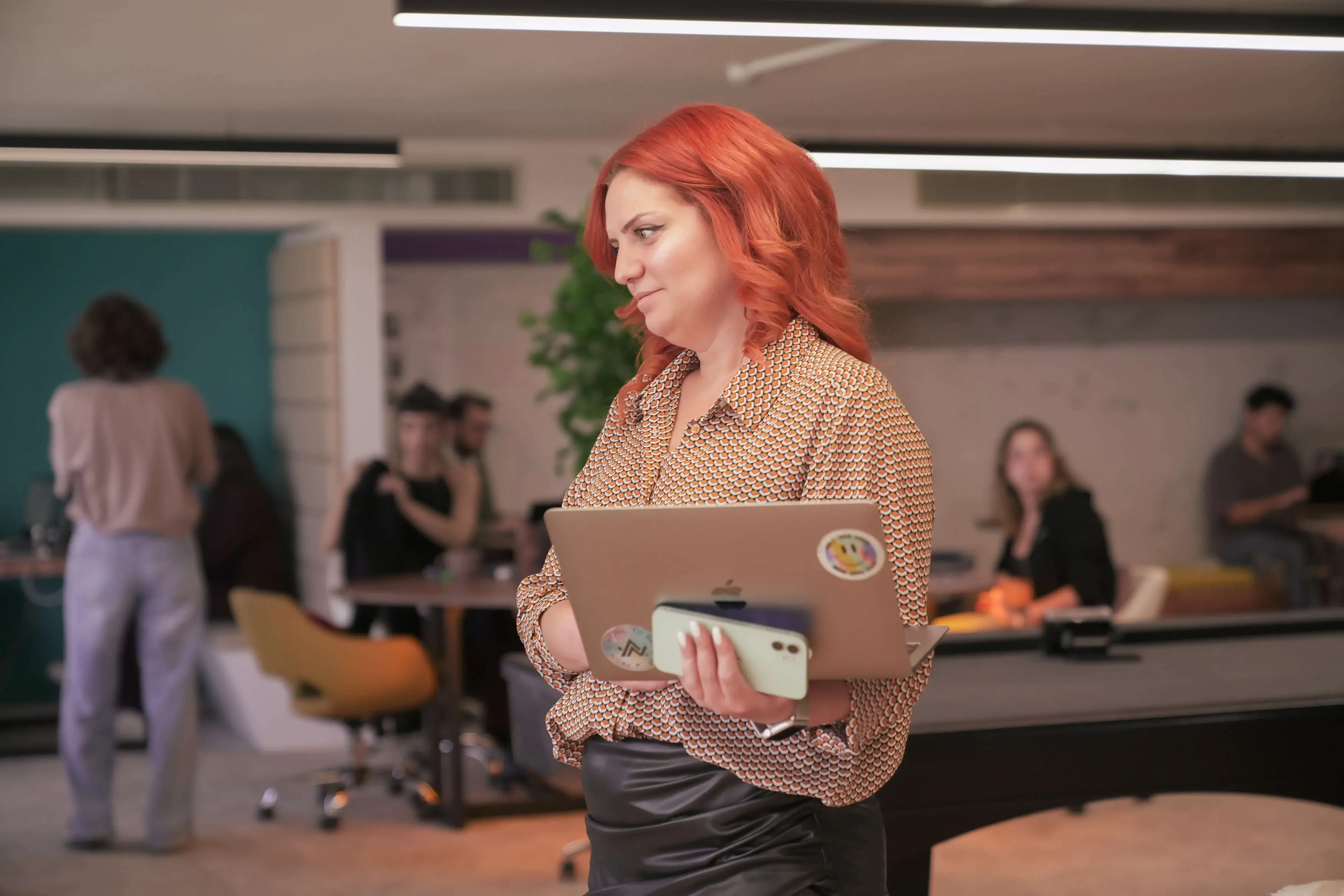 Neon Apps team member leading a discussion in the office with colleagues collaborating in the background.