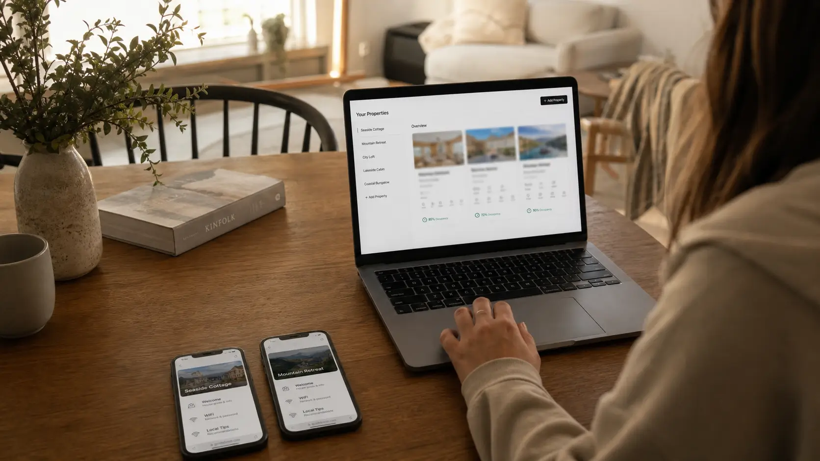 Operator at a laptop managing welcome books for two vacation rental properties.