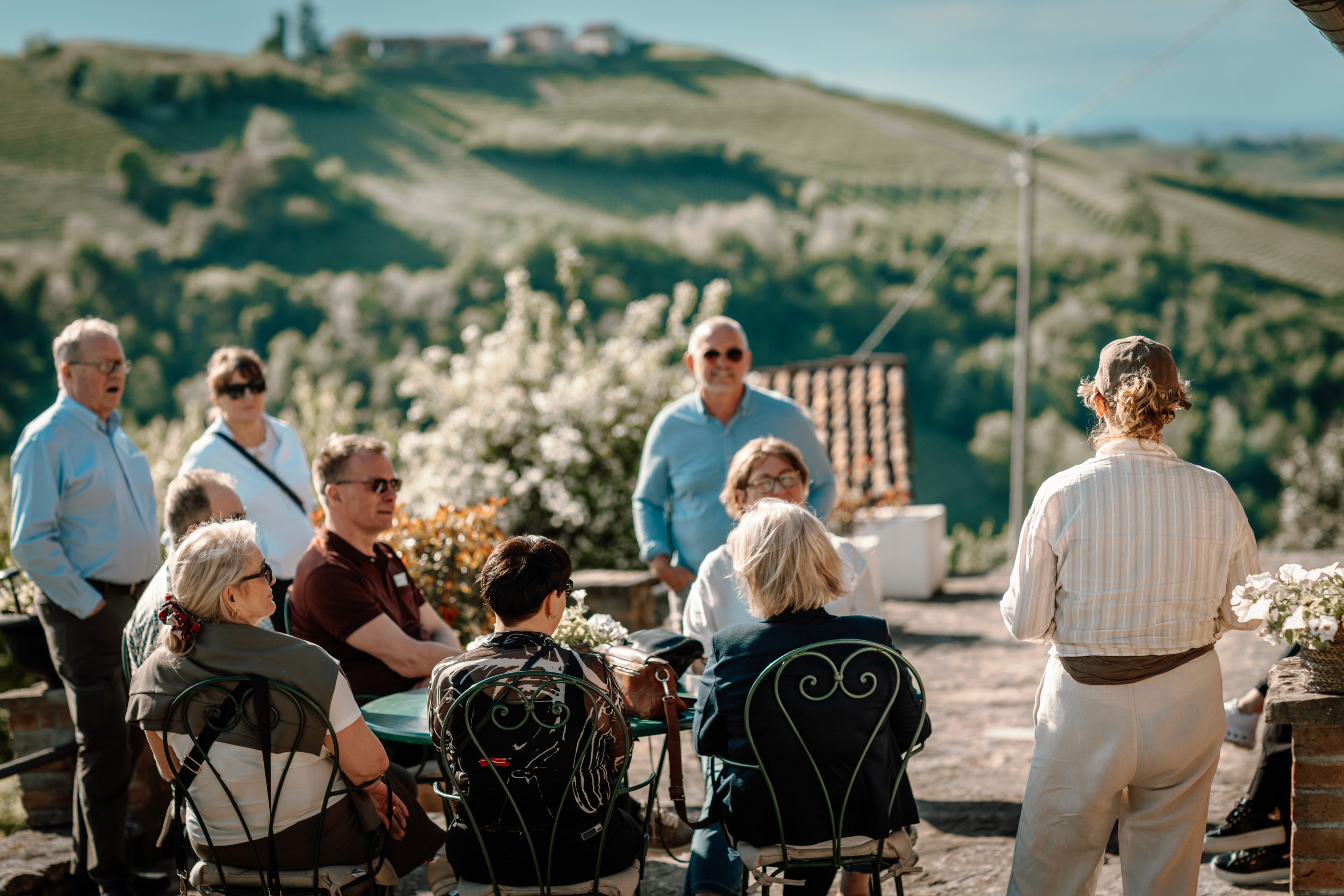 man in brown hoodie standing near green trees during daytime