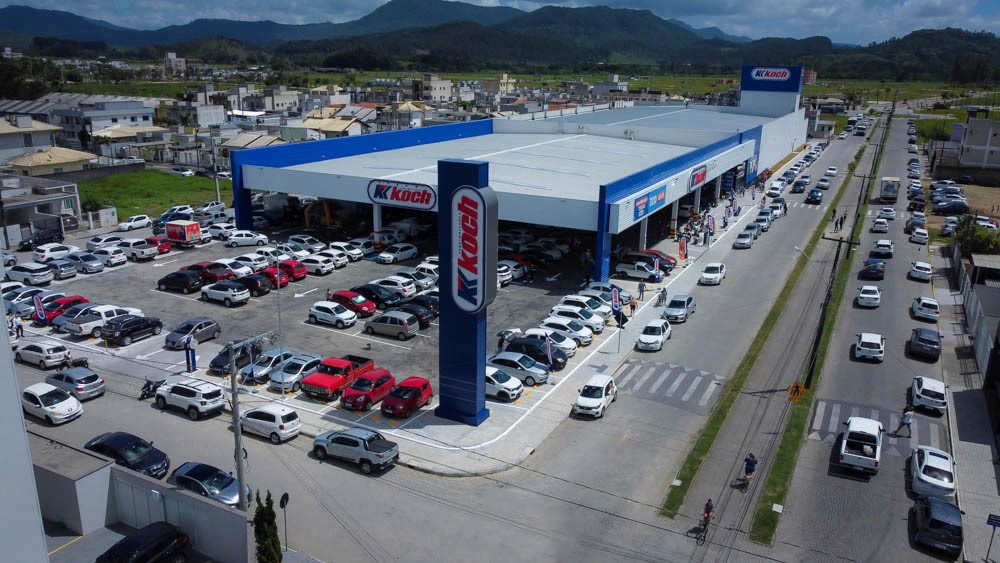 Black and white image of people working at a table with laptops, showing hands gesturing during discussion of digital content displayed on screens, with fabrica® logo in the corner.