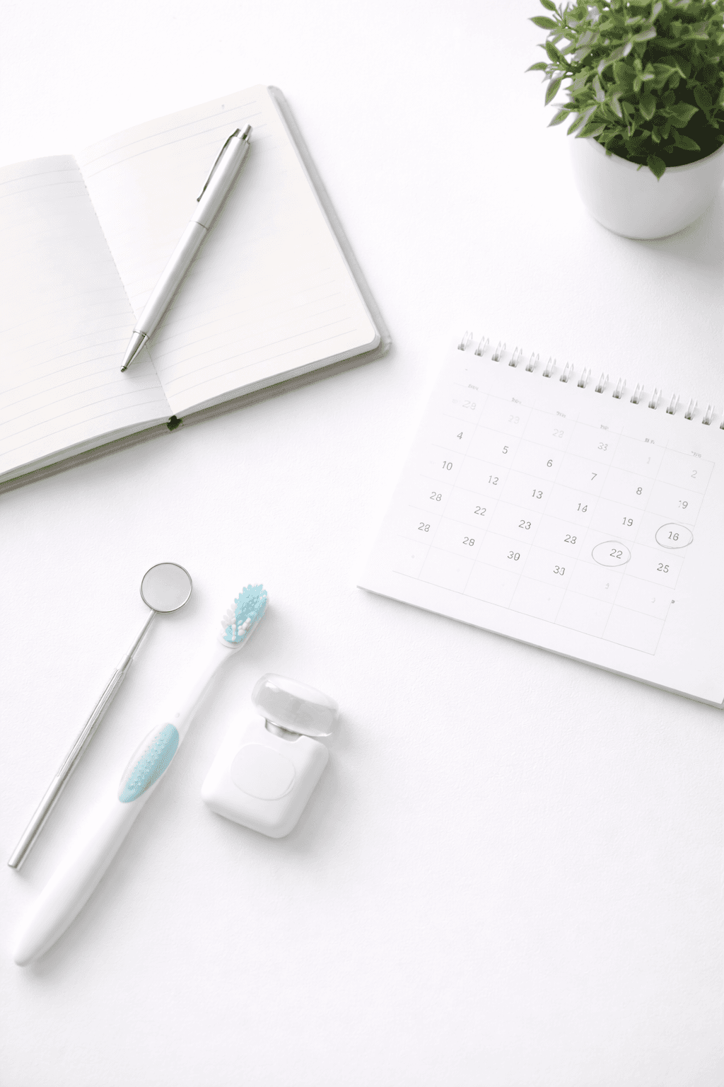Minimalist arrangement of a calendar page, notebook, pen, toothbrush, and dental floss on a white surface, representing follow-up care.