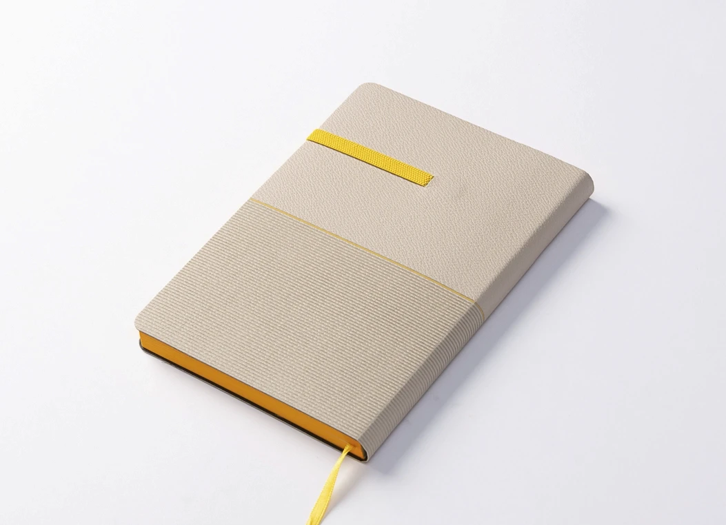 Front view of textured beige journal with yellow strap closure