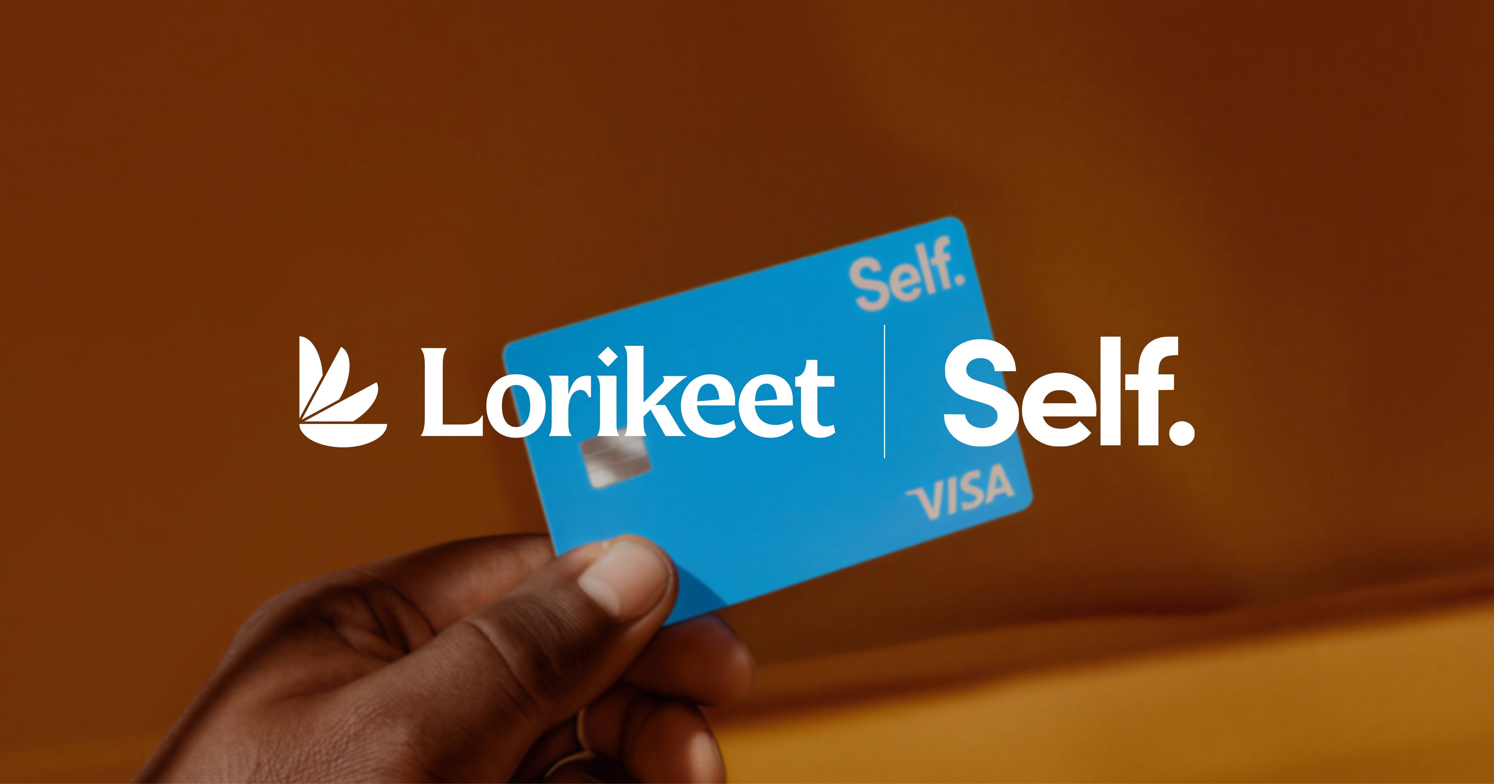 Hand holding blue Lorikeet Self Visa card against brown background, displaying card branding and logo.