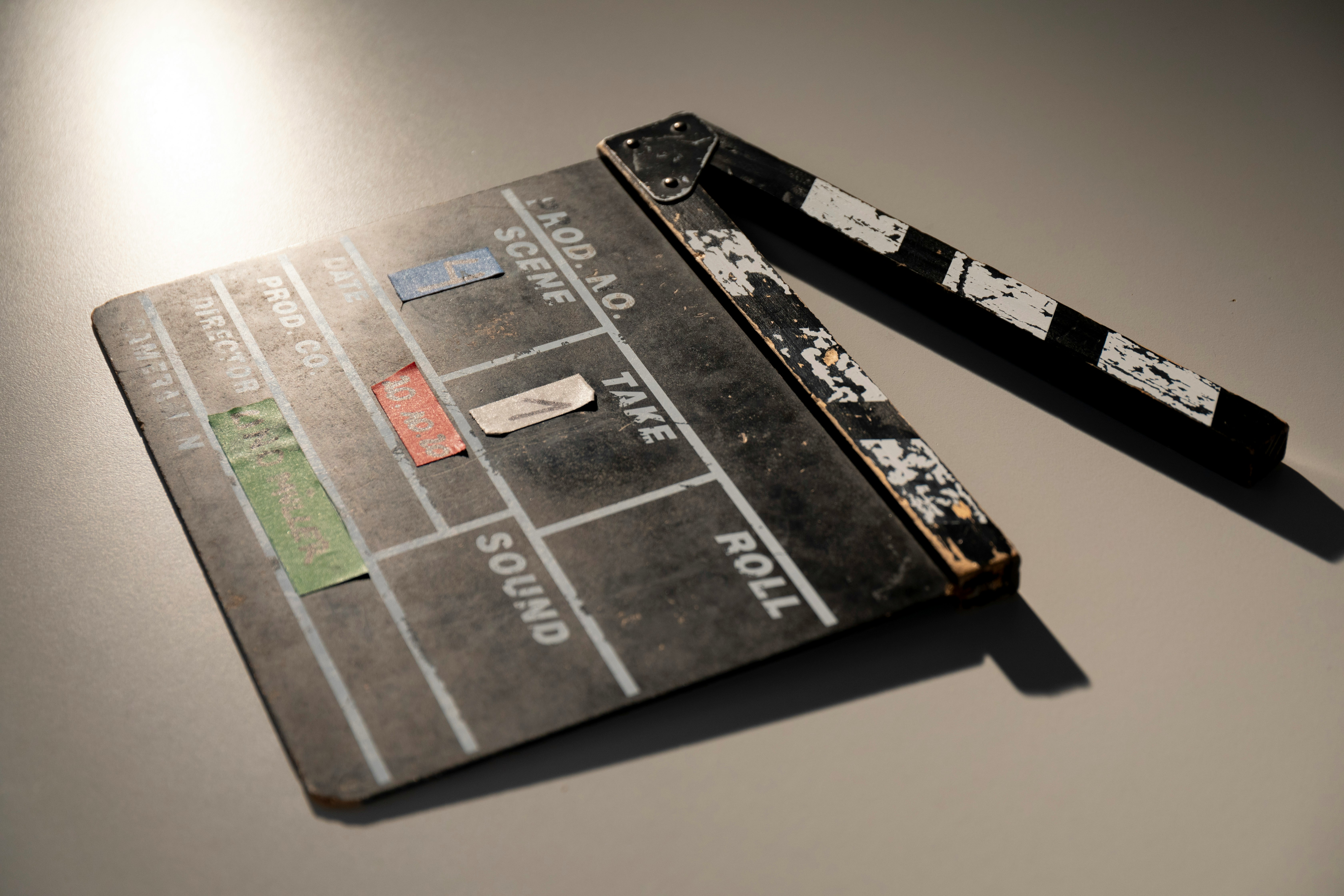 A black studio clapperboard on a beige counter