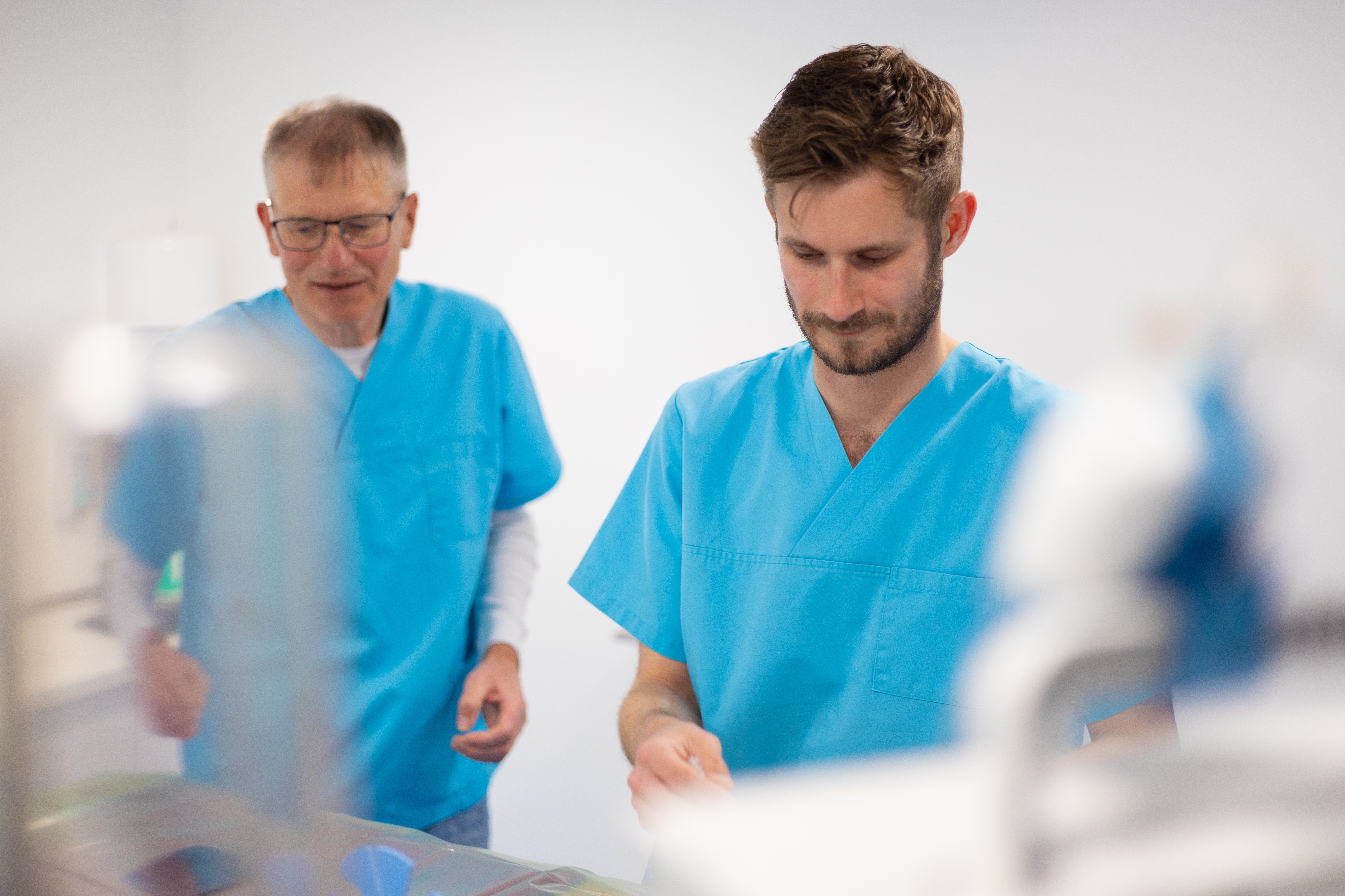 Zwei Tierärzte in blauen Arztkitteln in einer Tierarztpraxis.