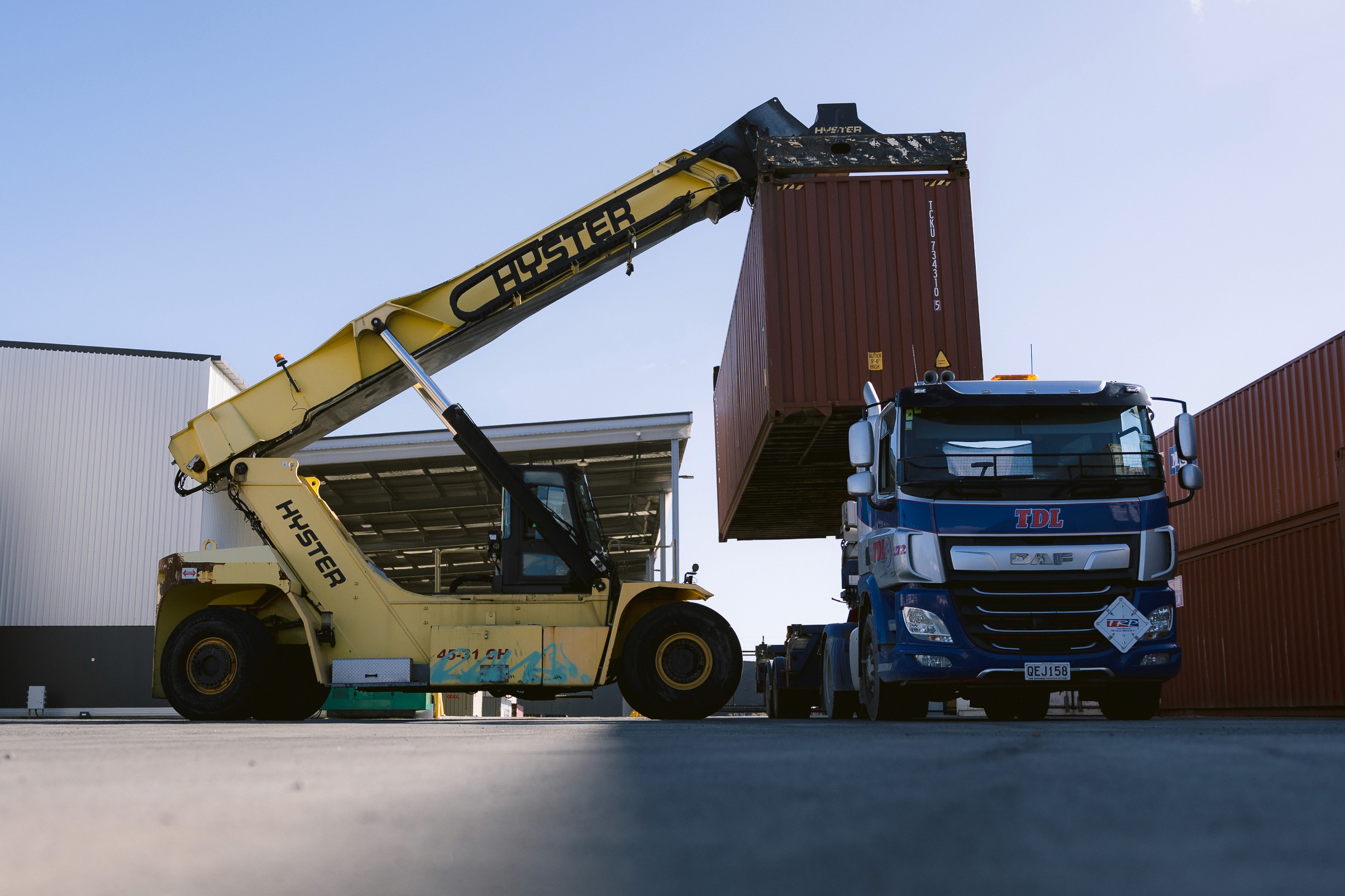 Cargo containers being loaded at the Port of Baltimore with cranes in motion.