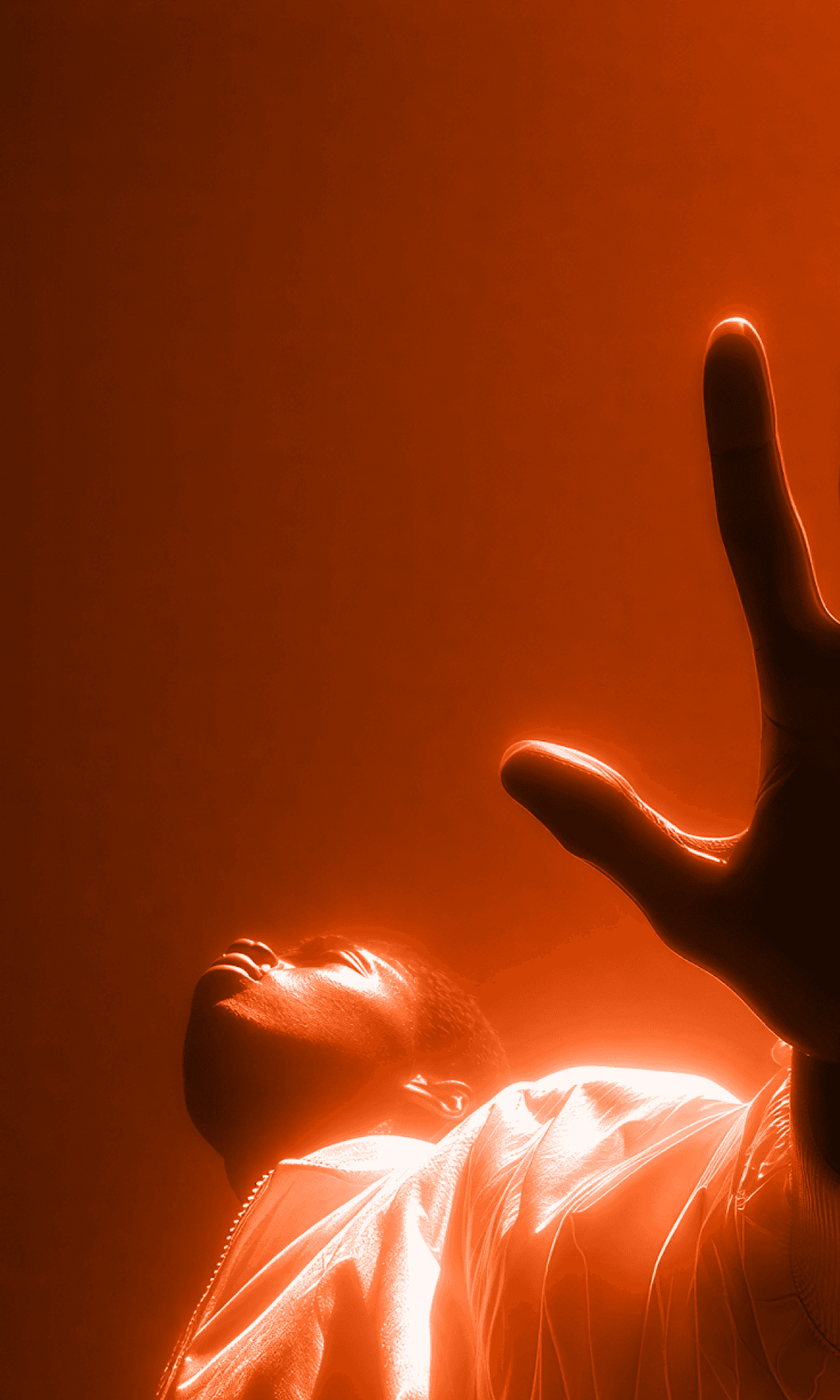 Person reaching upward with glowing orange light