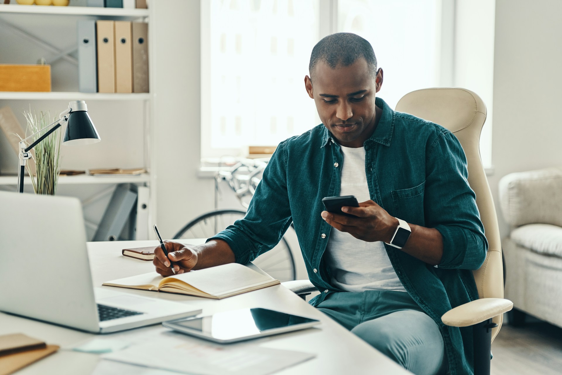 man on his phone sitting at a desk
