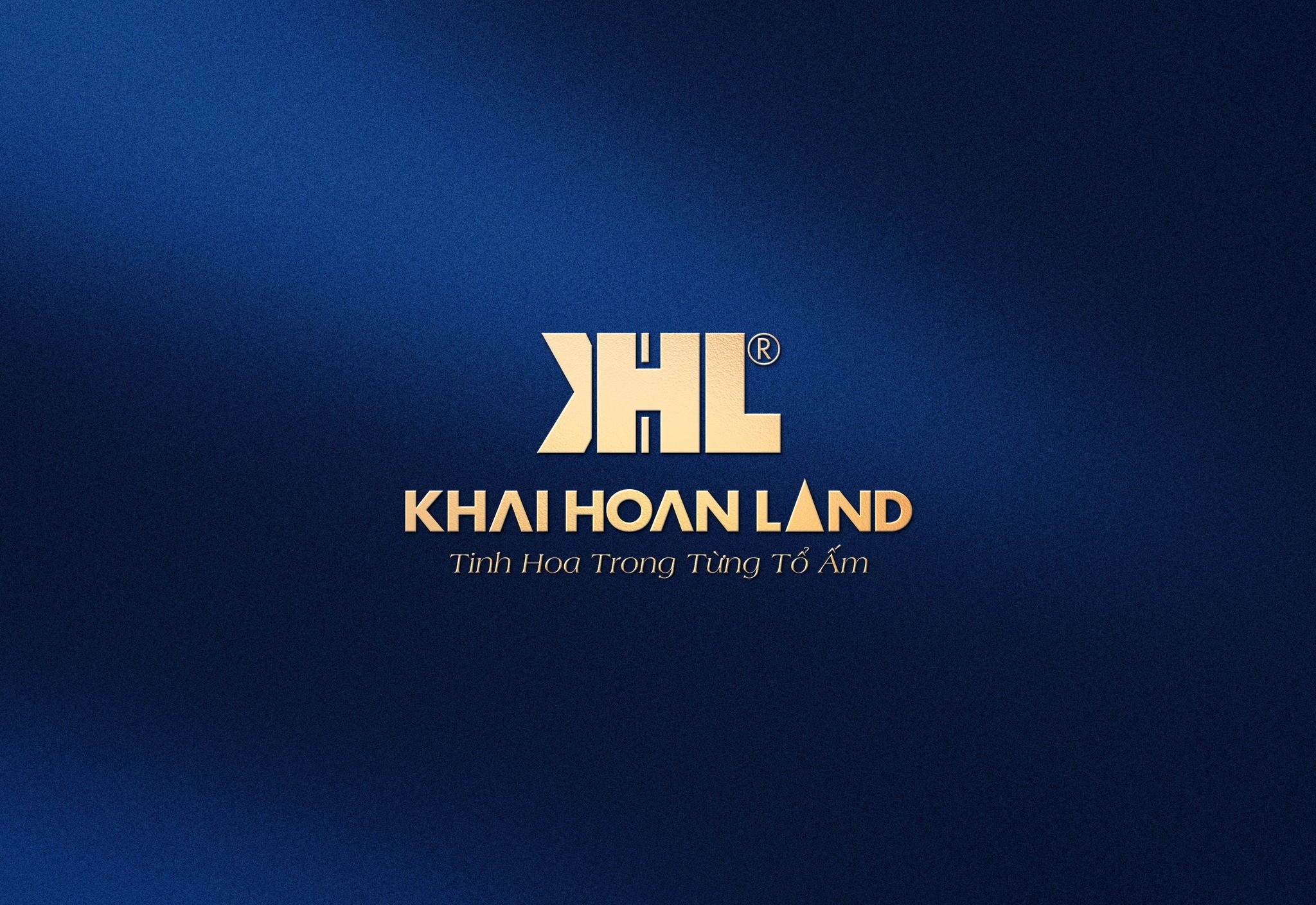 A woman with shoulder-length brown hair and freckles smiles softly. She wears a light gray blazer and white shirt, sitting in a warmly lit room.