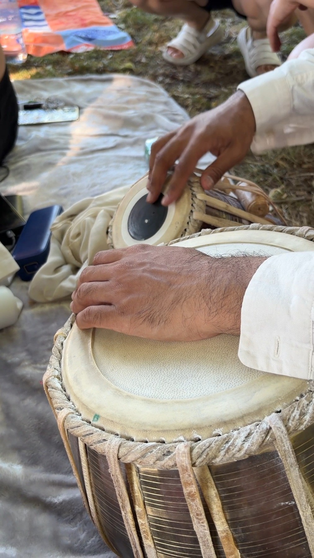 Close-up of hands playing tabla outdoors at Unplug: The Sound of Sleeping