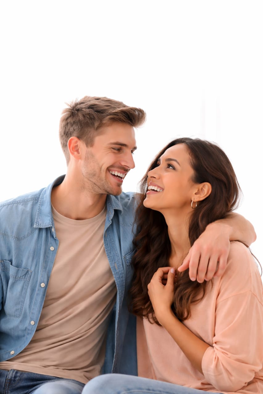 Smiling couple making eye contact and showing affection, illustrating clear signs of romantic interest and attraction