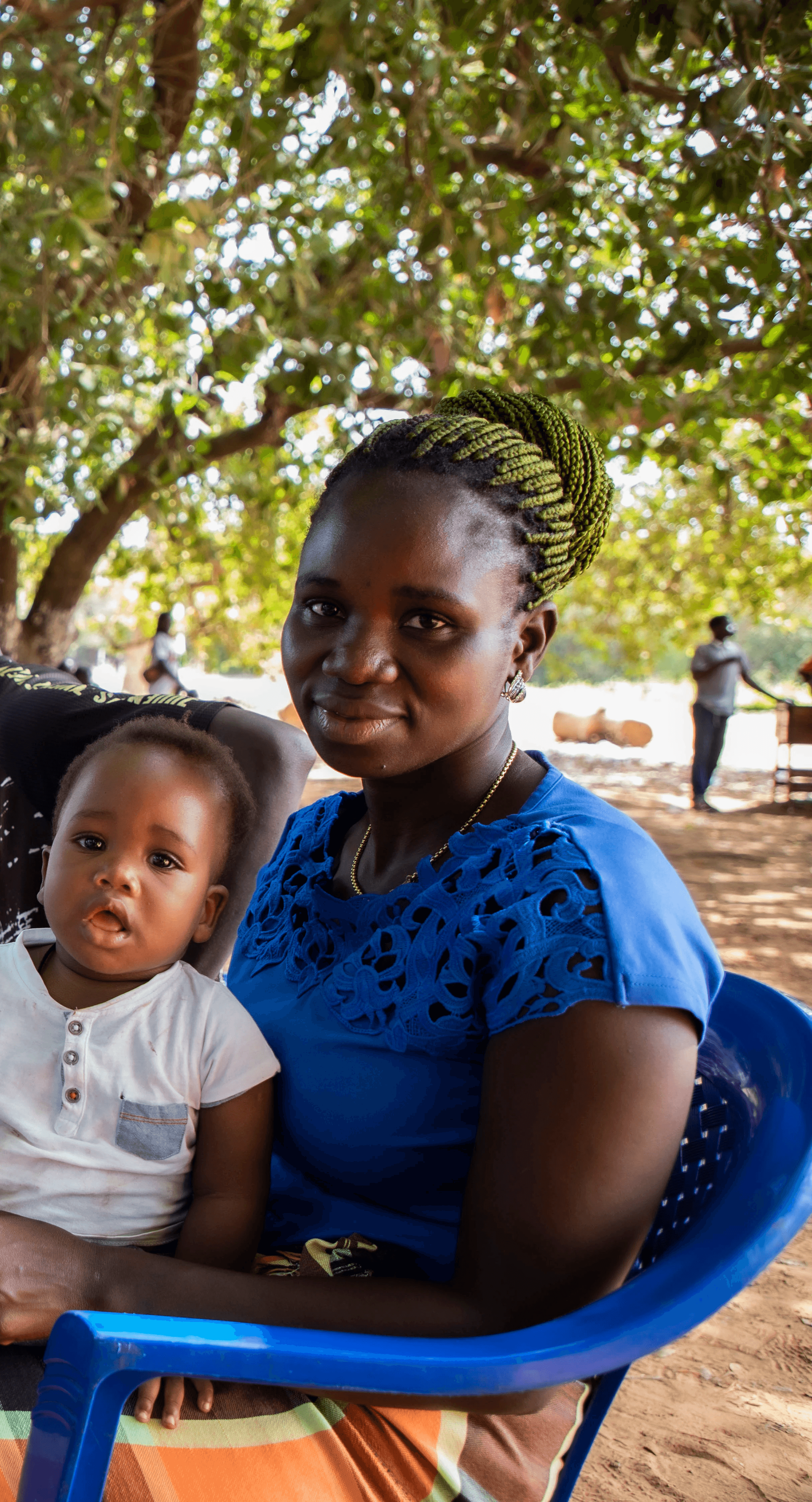 Smiling young man with short hair poses against a dark background, wearing a green button-up shirt.