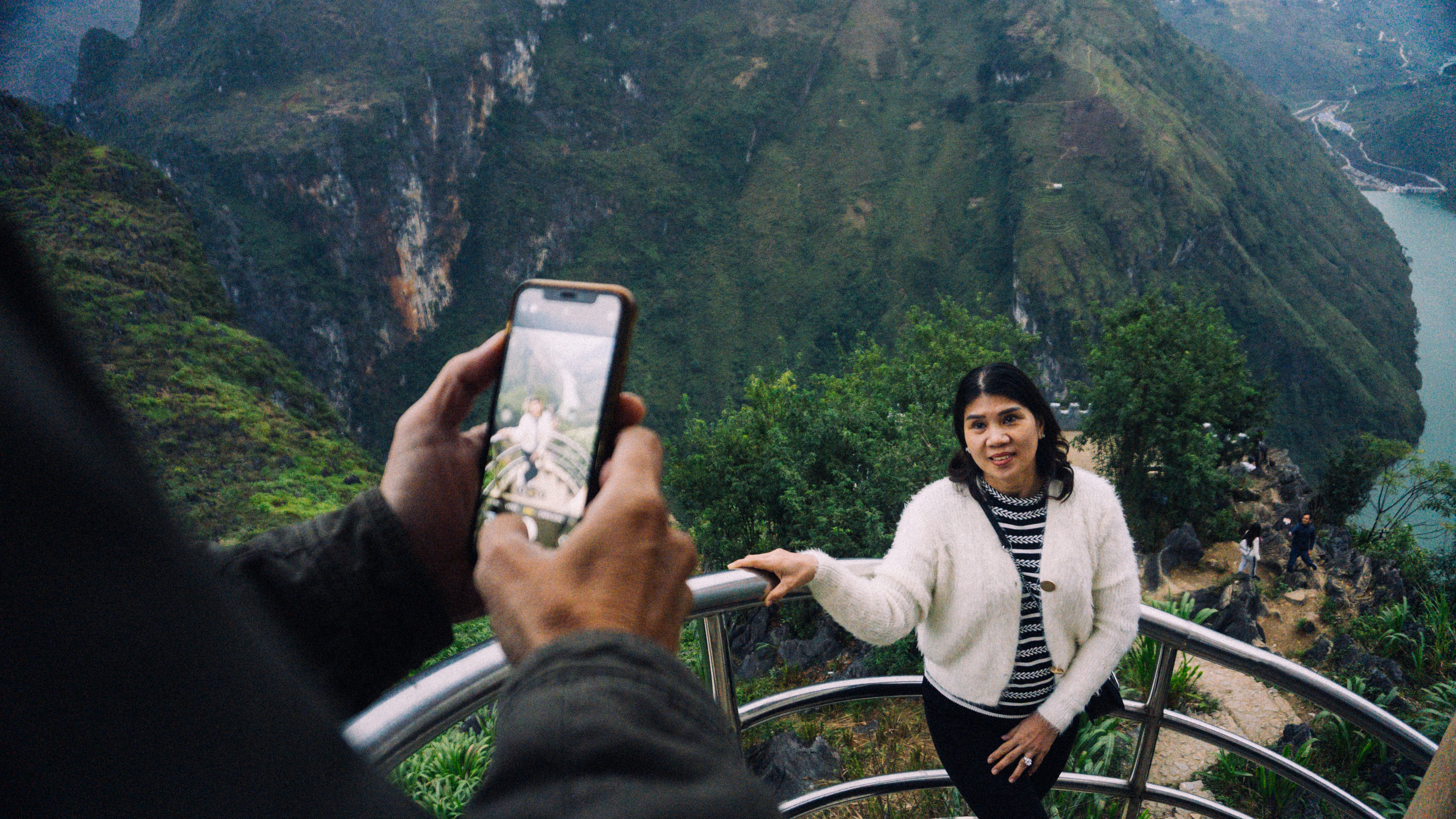 a person taking a picture of a woman on her phone