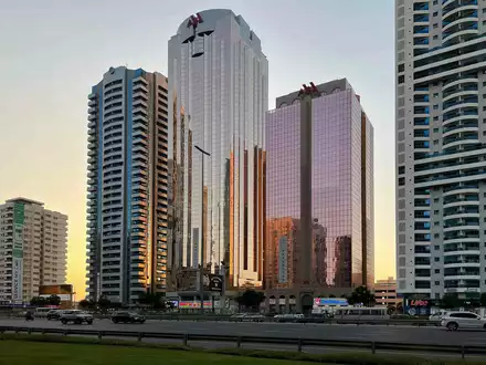 Wide shot of commercial buildings. Real estate agent services for listings in Al Moosa Tower 2 and vicinity.
