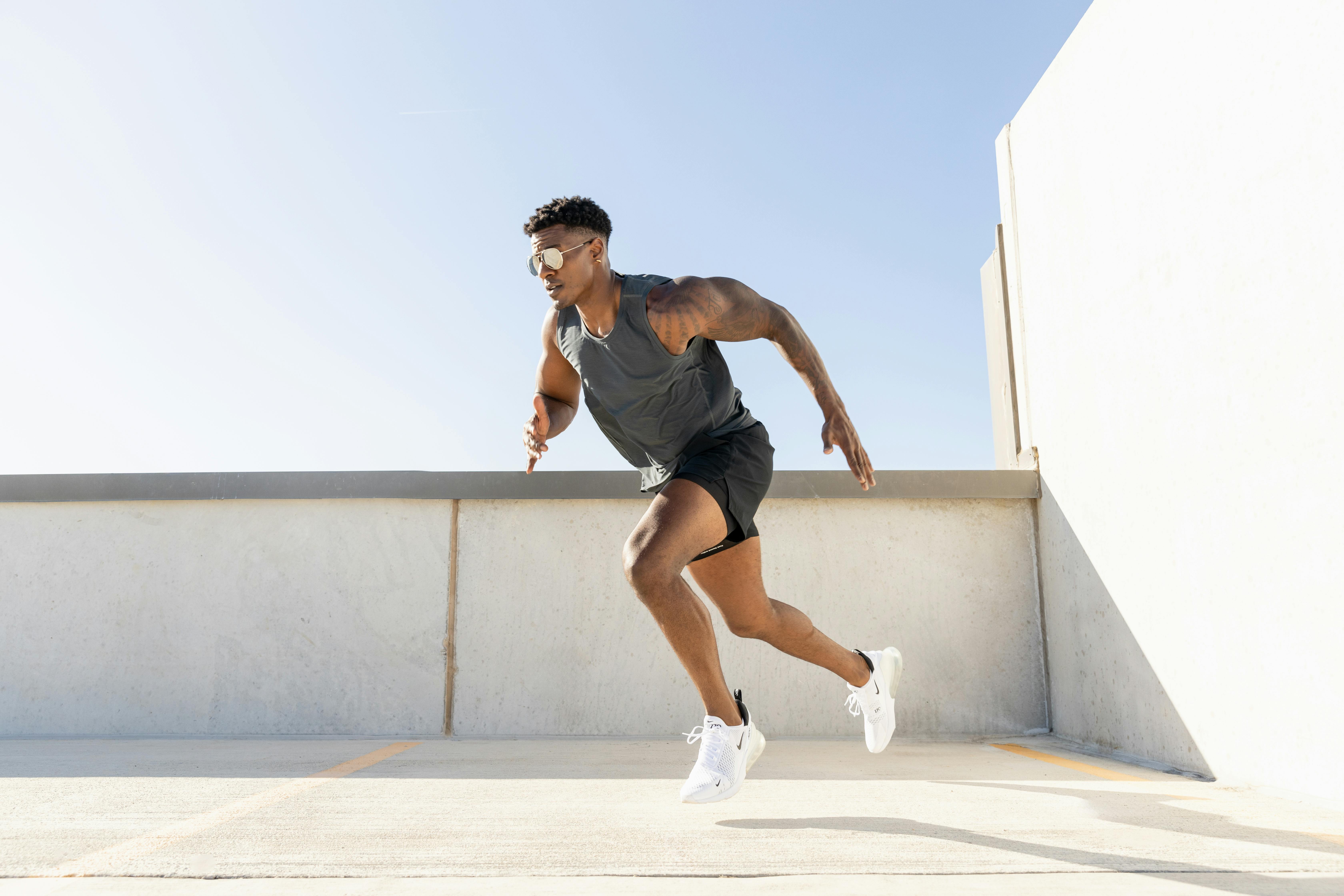 Man running in a sports outfit in a sunny environment.