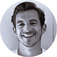 A smiling man wearing a white shirt, exuding a friendly and approachable demeanor.
