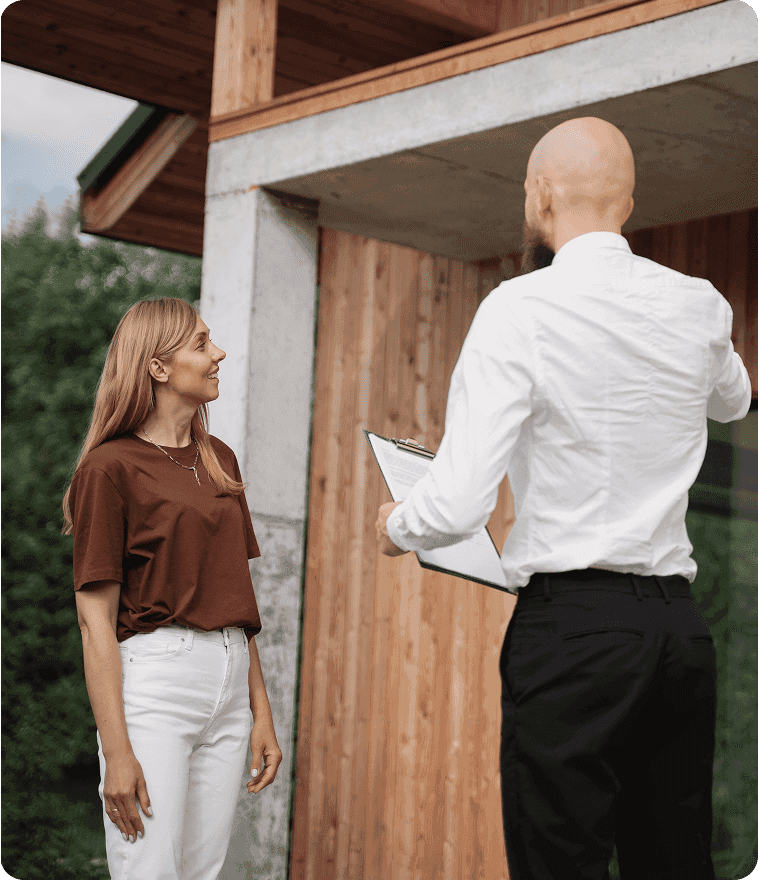 Professional door consultant with a clipboard speaking to a homeowner outside a modern residential building. Showcasing on-site project assessment, custom door consultation, and expert architectural planning services.
