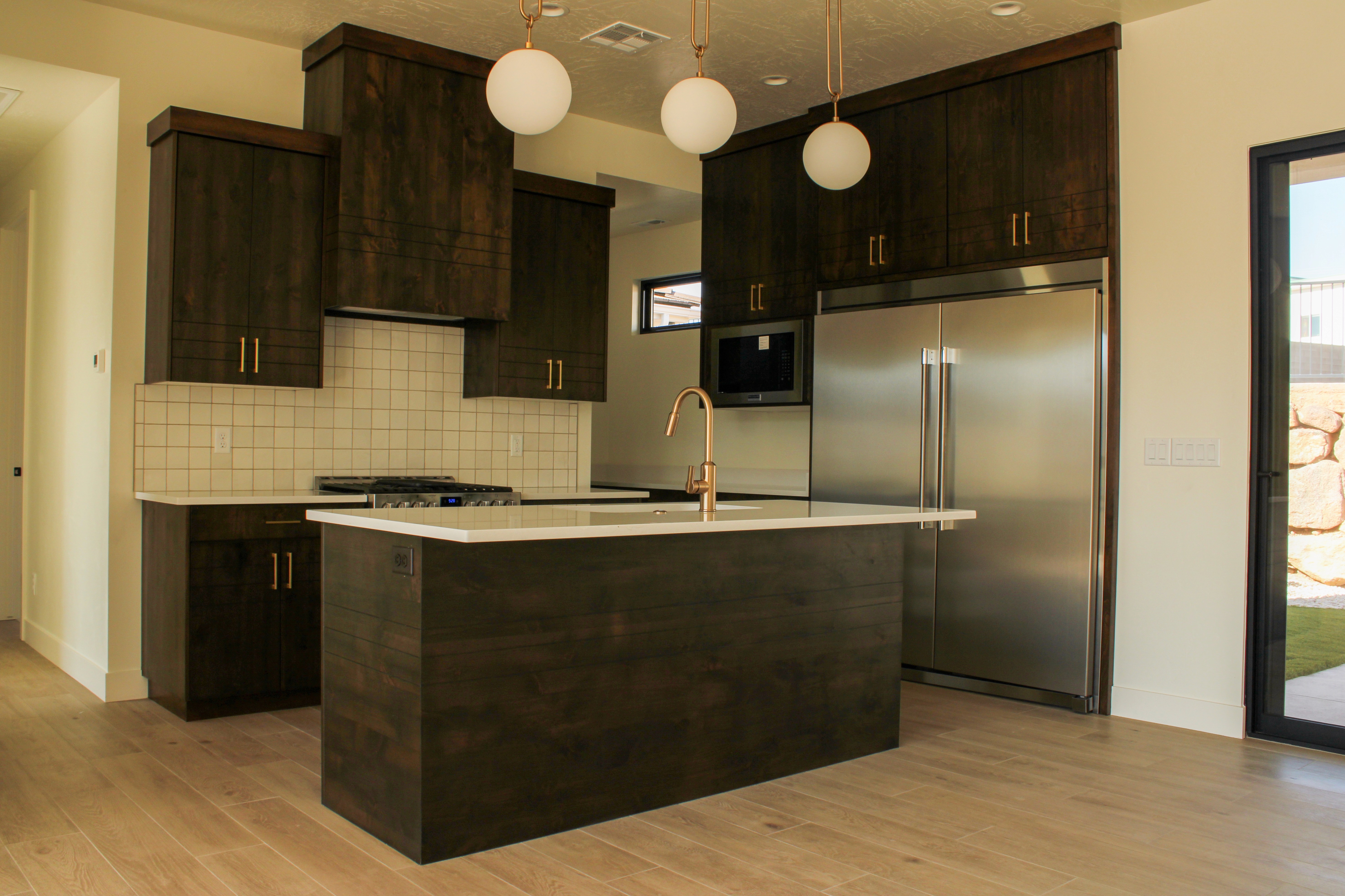 Custom kitchen layout at The Overlook at Falcon Ridge in Hurricane, Utah, highlighting cabinetry, island seating, and modern appliances.