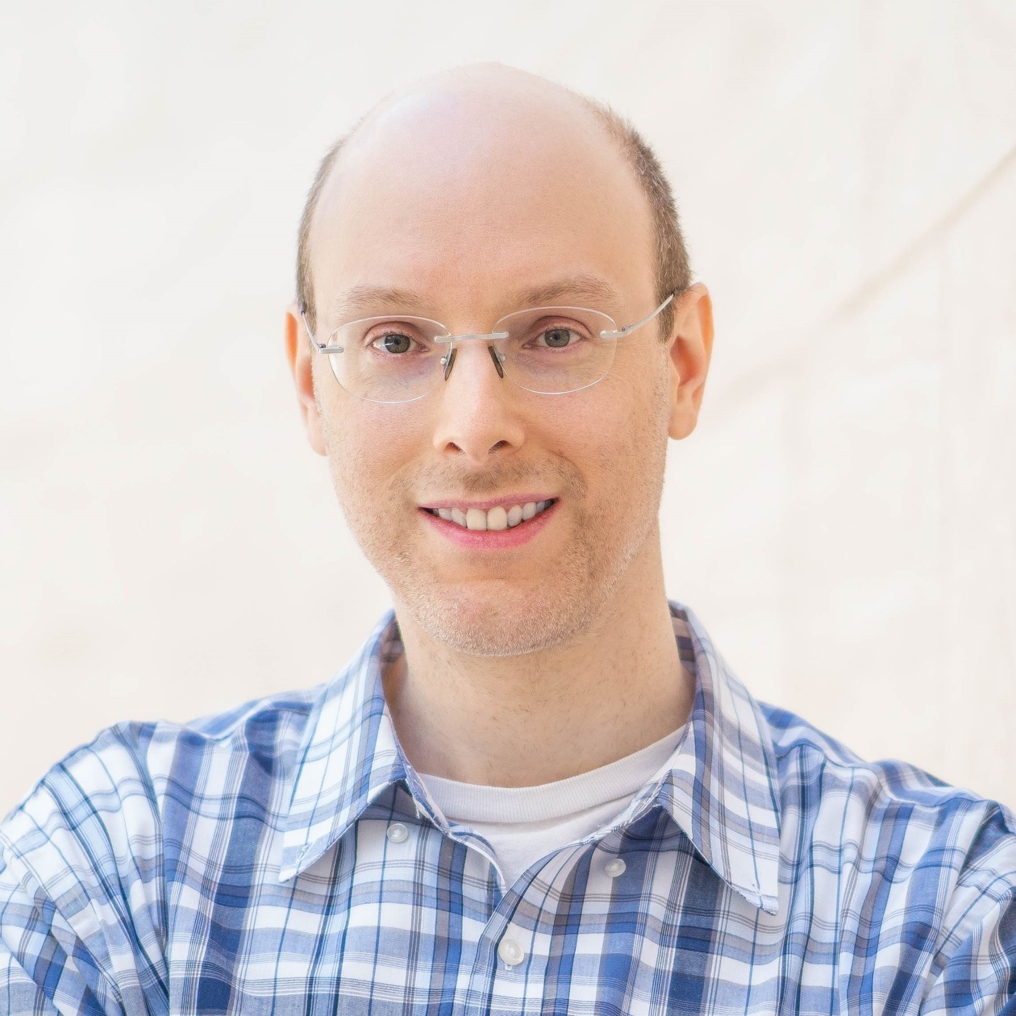 Portrait of Dr. Dan Winer, Propion cofounder and aging-science researcher, wearing glasses and a blue plaid shirt.