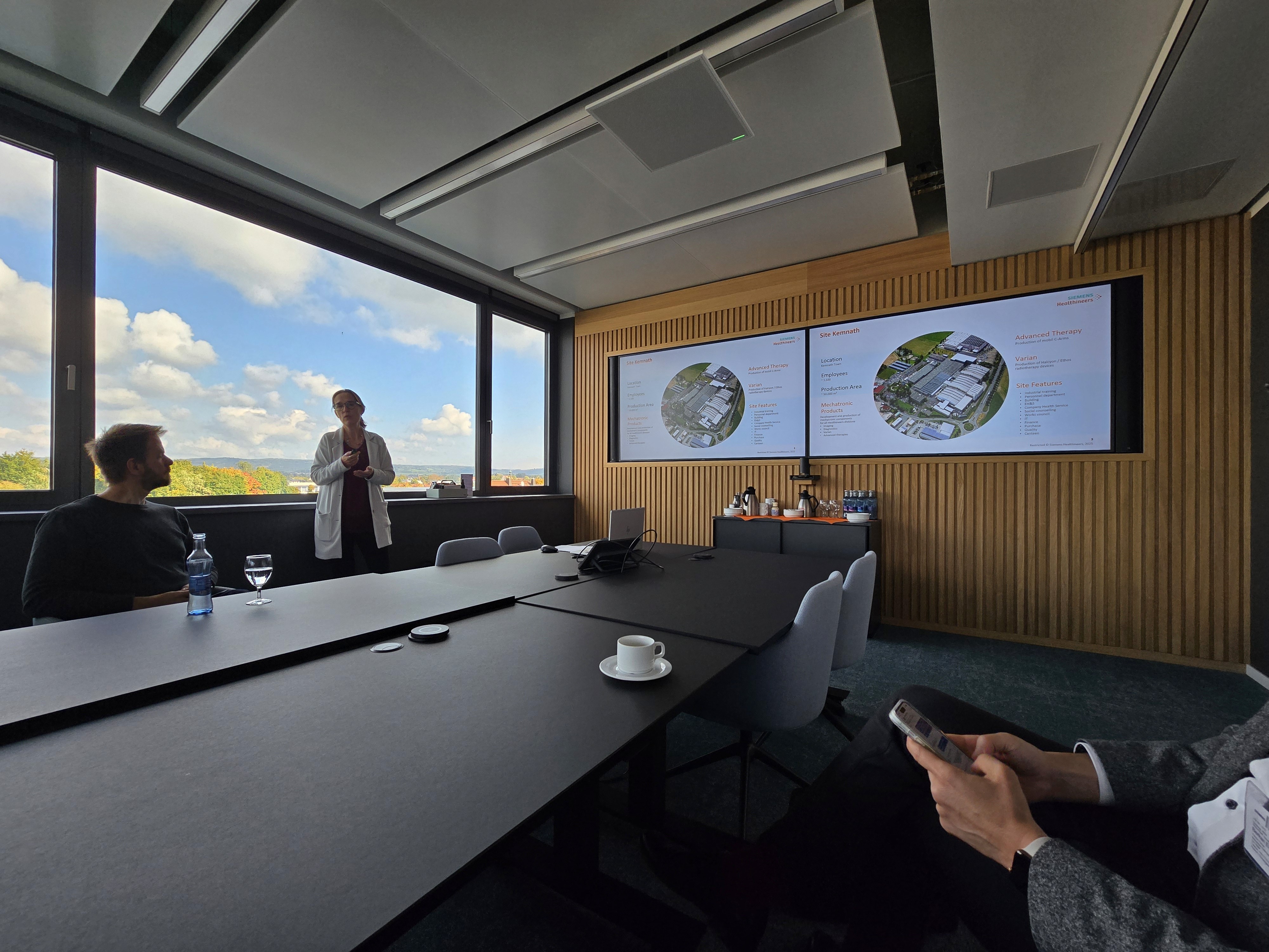 Frau steht mit Blumen in der Hand an Wand