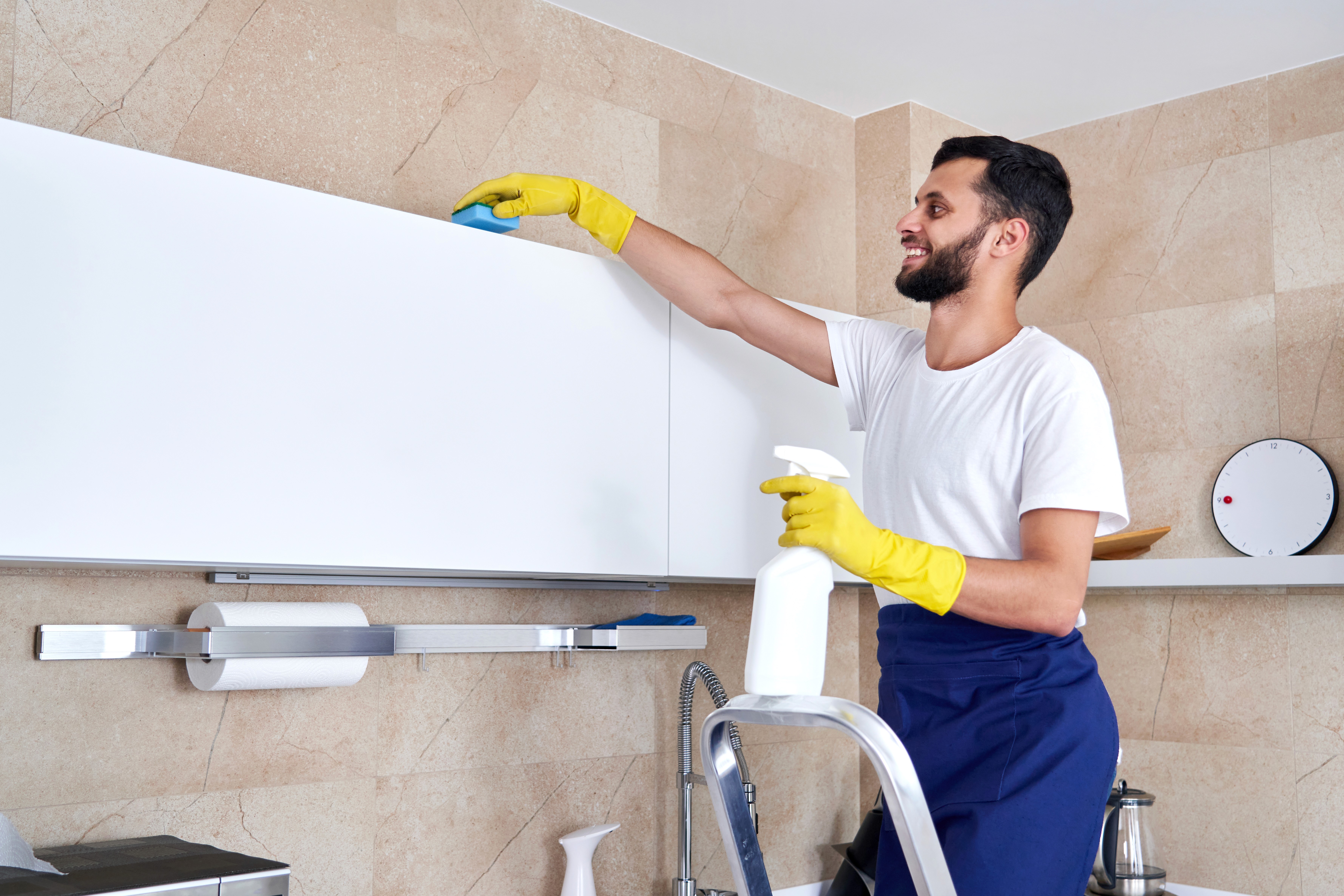 a woman is cleaning a kitchen sink with a rag