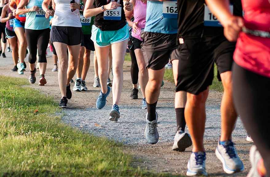 Large group of people running in a race, only their legs are visible