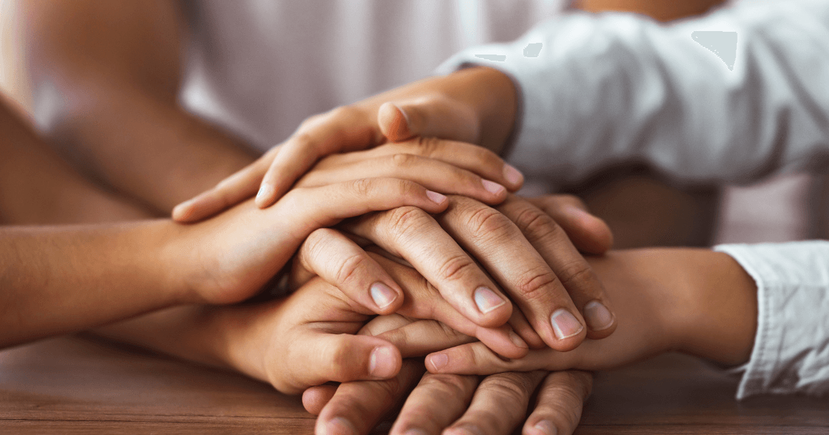 A family hugging or holding hands, symbolizing unity and support.