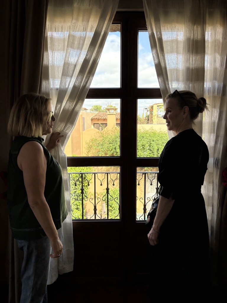 Two women standing at a window in San Miguel de Allende