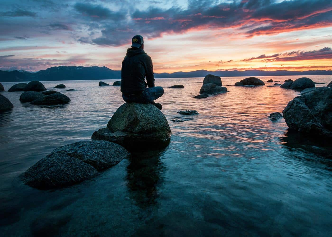 Sleep spindles psychology - Man sitting on a rock at sunset