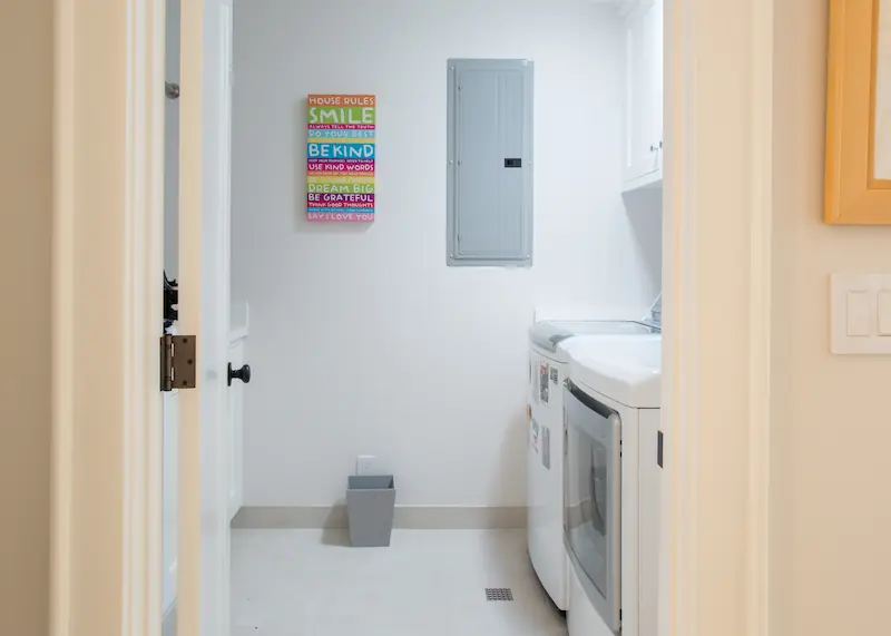 Laundry room seen from entrance door with white appliances and tile floor from the Big Canyon Remodel project. Photo by Chris Darnall.