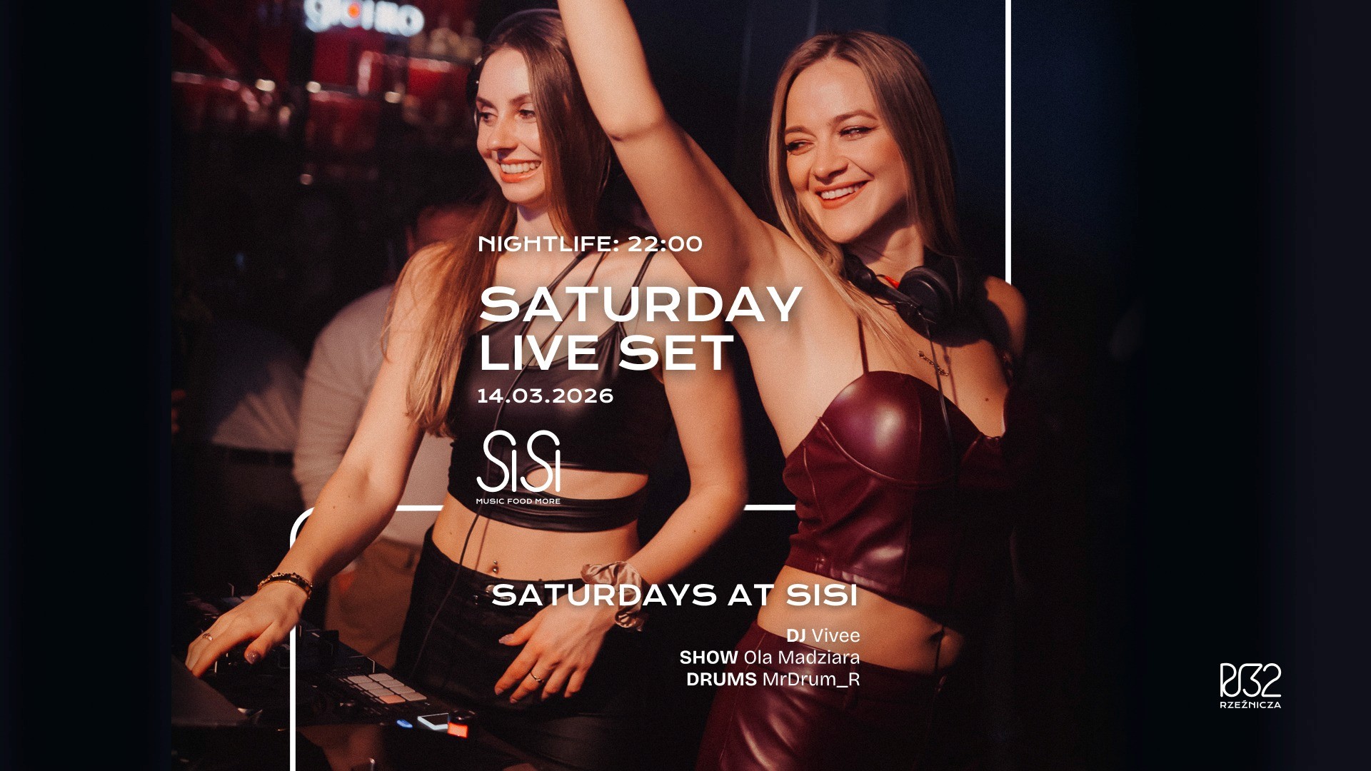 A winding road cuts through rocky terrain, surrounded by patches of green grass and illuminated by sunlight.