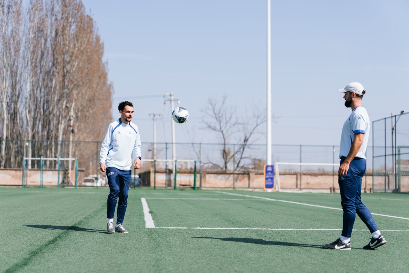 Student practising football control in the sports hall